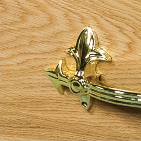 Ornate brass handle bracket mounted on the oak veneered side of The Haddon